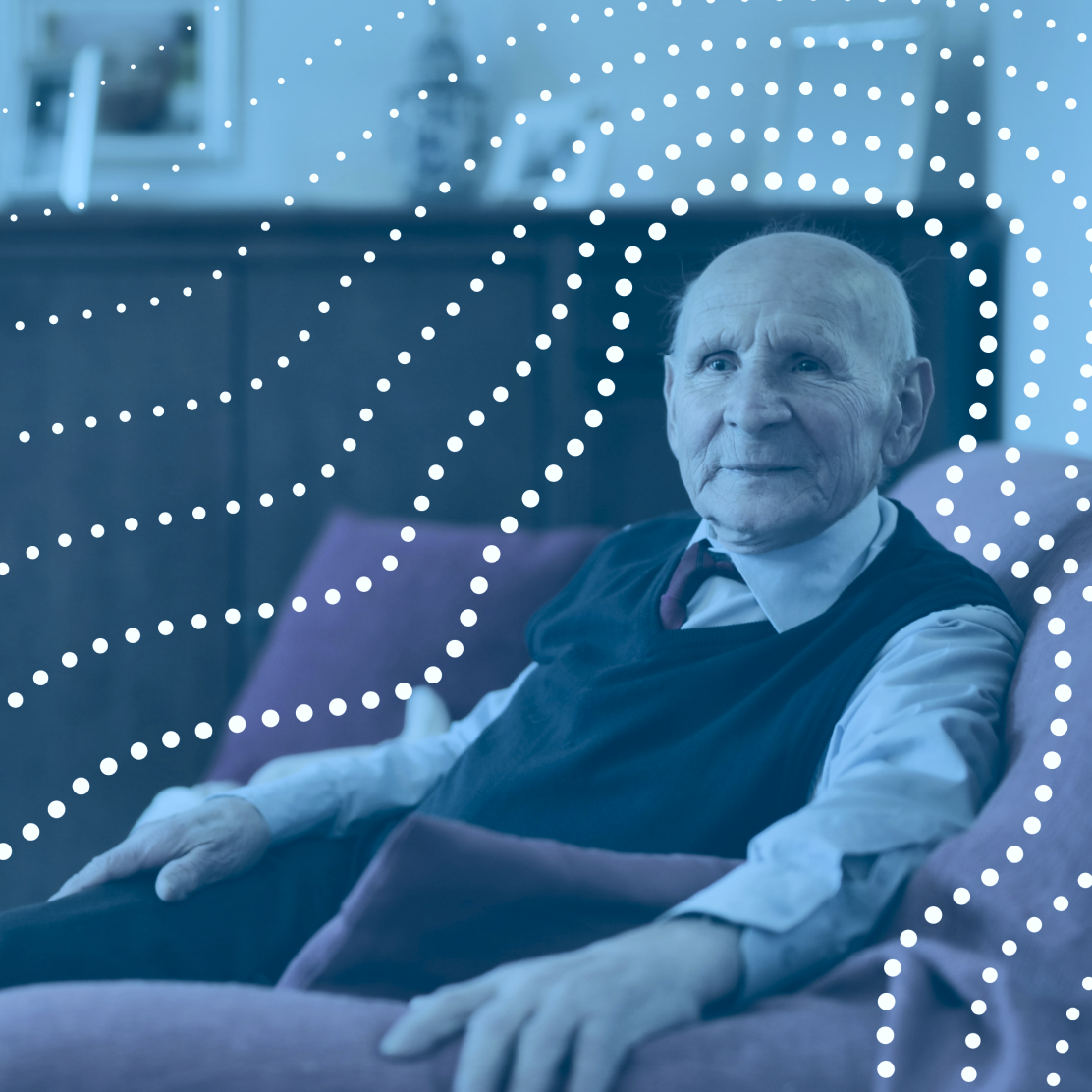Photo of a smiling elderly man sitting in an armchair