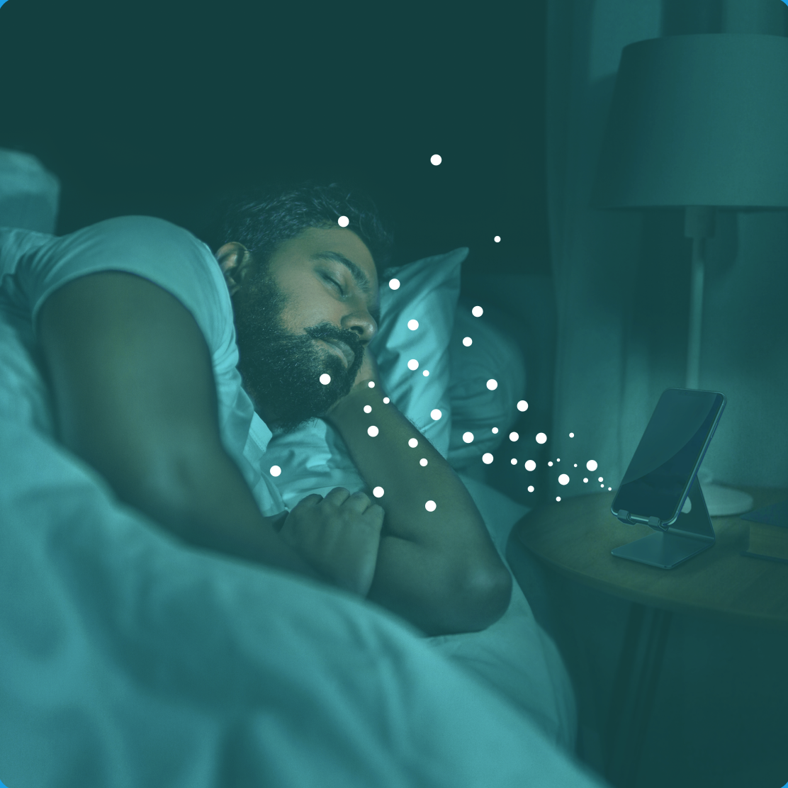 Photo of man sleeping in bed while his skin outgasings are analysed by a bed-side device